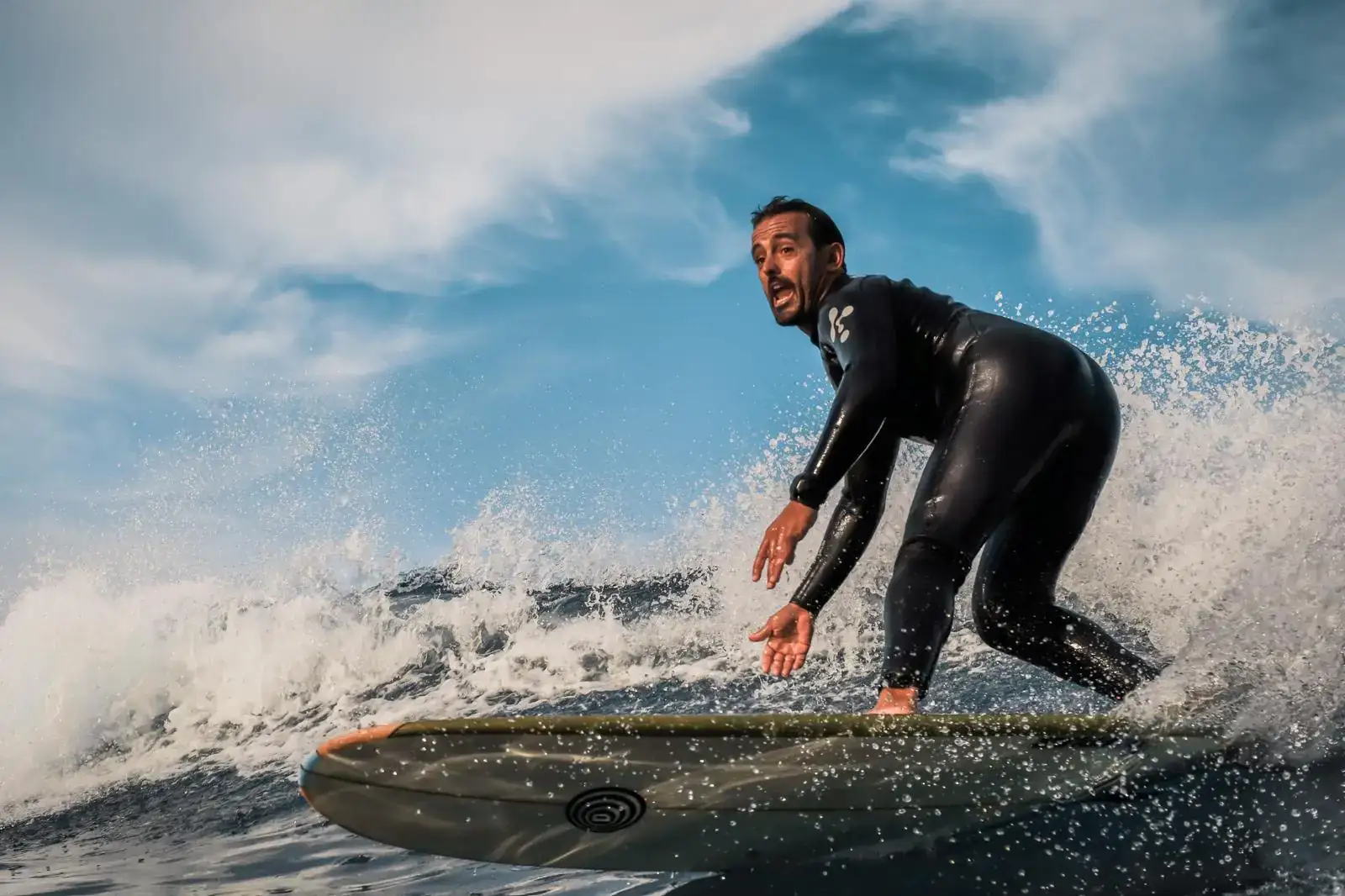 Surfcoach gibt privates Feedback direkt neben seinem Schüler im Wasser